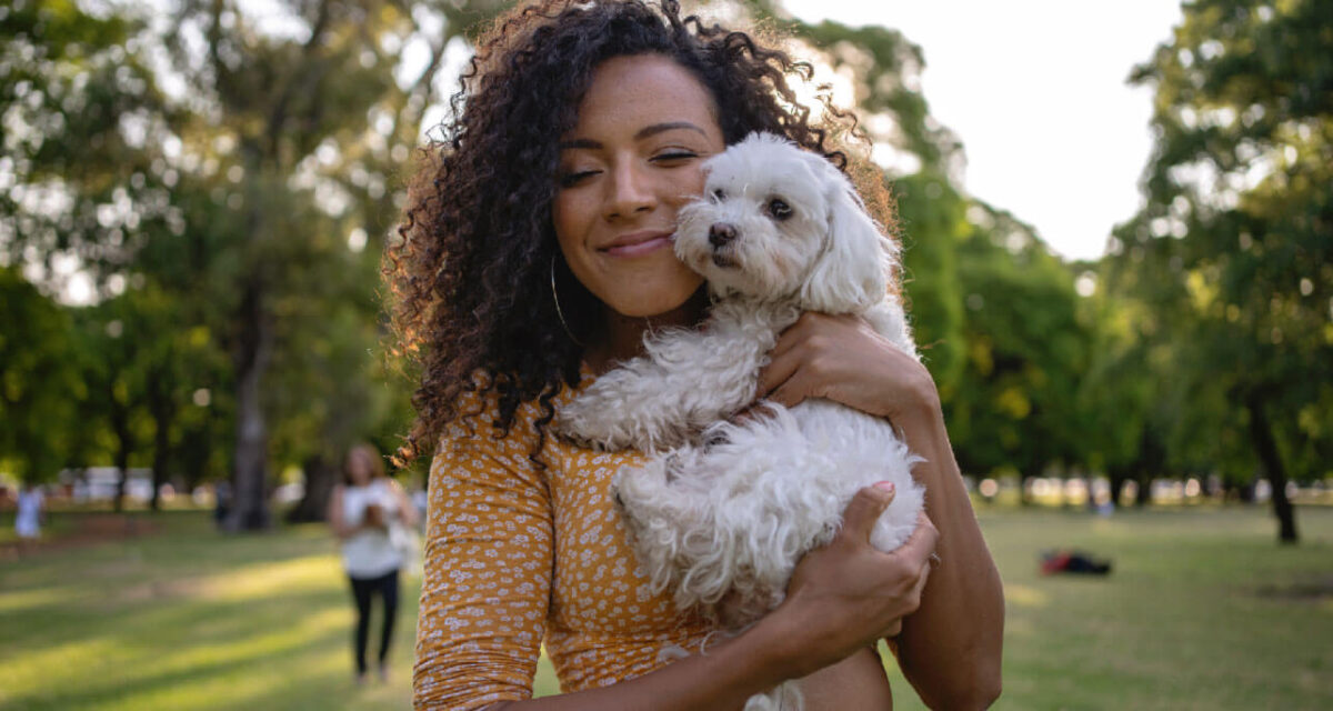young-lady-cuddling-a-small-white-dog young-lady-cuddling-a-small-white-dog
